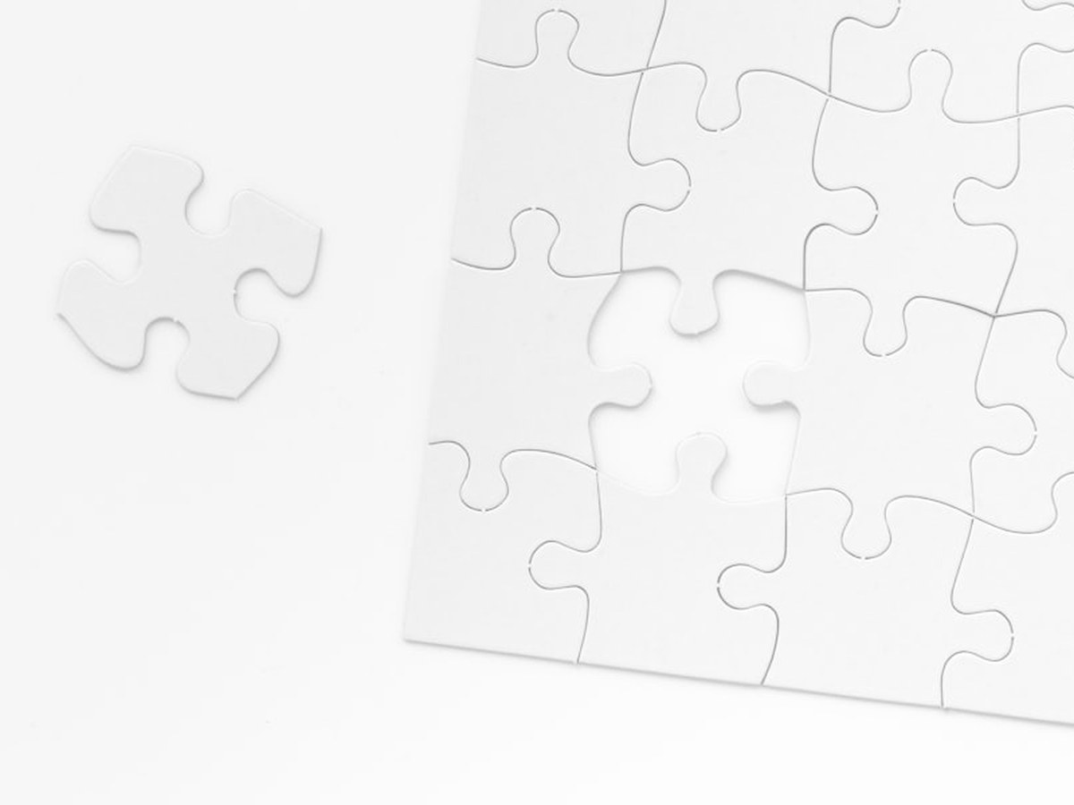 White jigsaw puzzle with one loose piece beside it