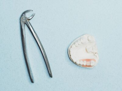 Dental extraction forceps beside a partial denture