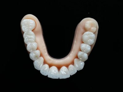 Full arch of artificial teeth against a black background