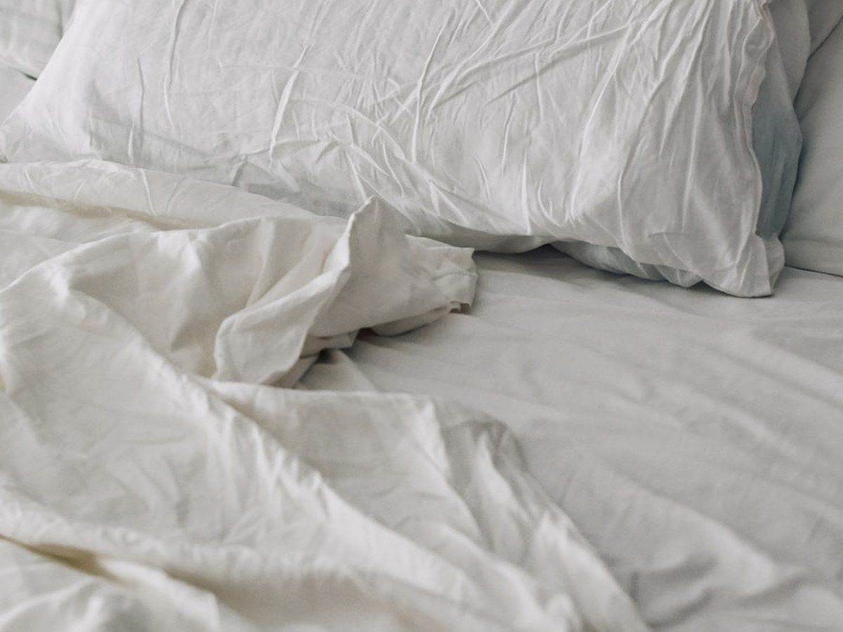 Rumpled white bedding on a bed