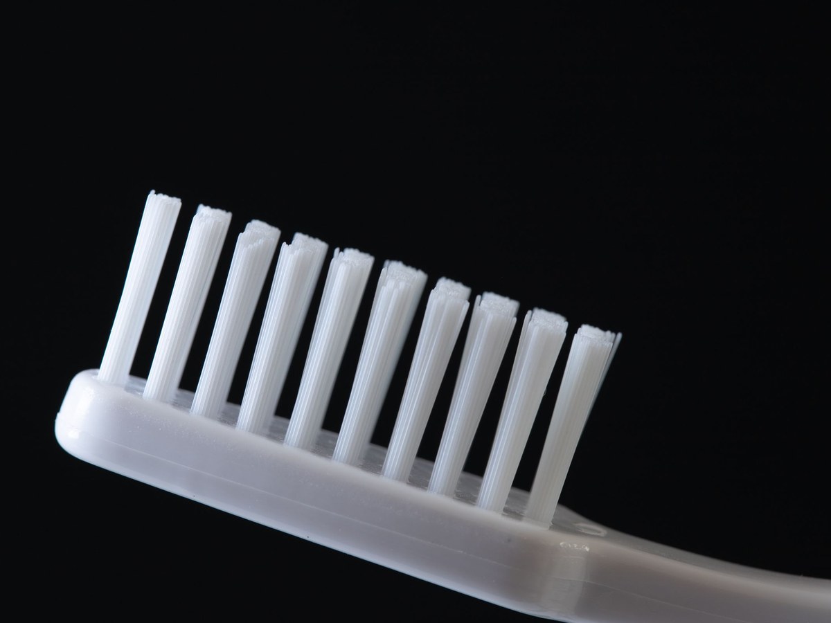Close-up of white toothbrush bristles against a black background